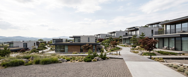 A hillside community of low-rise villas with planted walkways between them